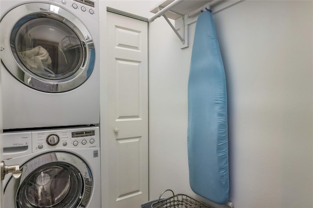 clothes washing area with stacked washing maching and dryer