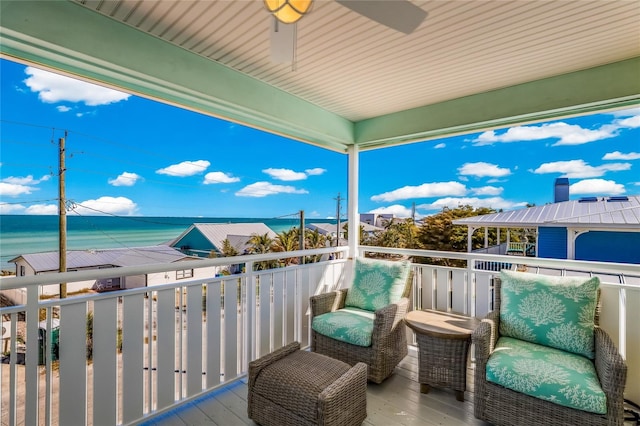 balcony featuring ceiling fan and a water view