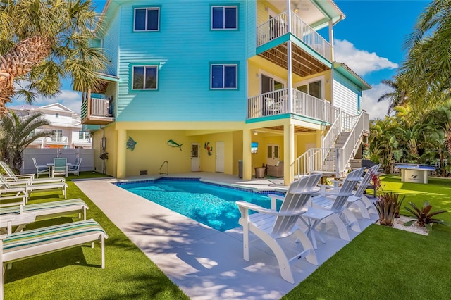 back of property featuring a patio area, a balcony, and a yard