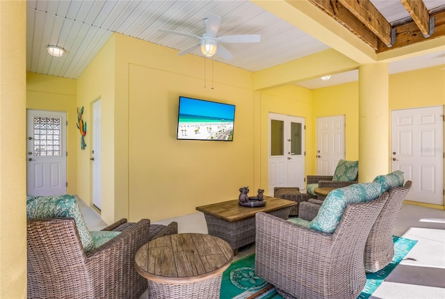 living room with ceiling fan and beamed ceiling