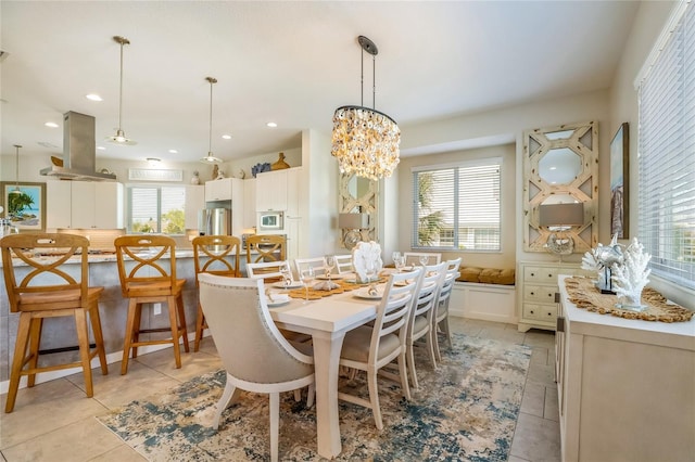 dining room with light tile patterned floors, a healthy amount of sunlight, and an inviting chandelier