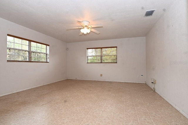 empty room with ceiling fan and light tile floors