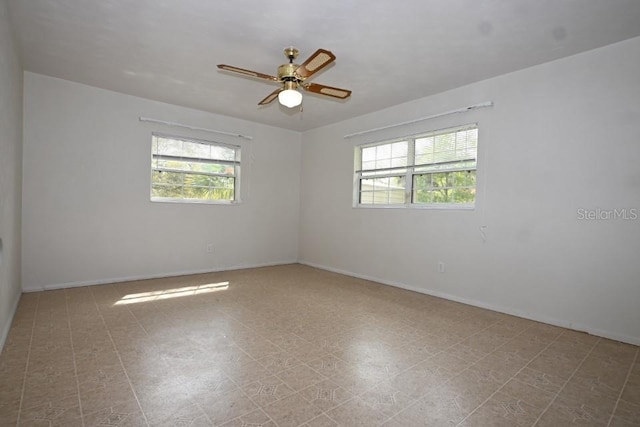 tiled spare room featuring a healthy amount of sunlight and ceiling fan