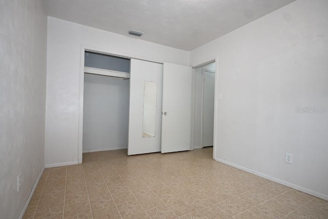 unfurnished bedroom featuring a closet and light tile flooring