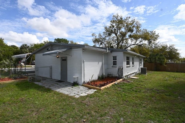 rear view of house with a lawn and central AC unit