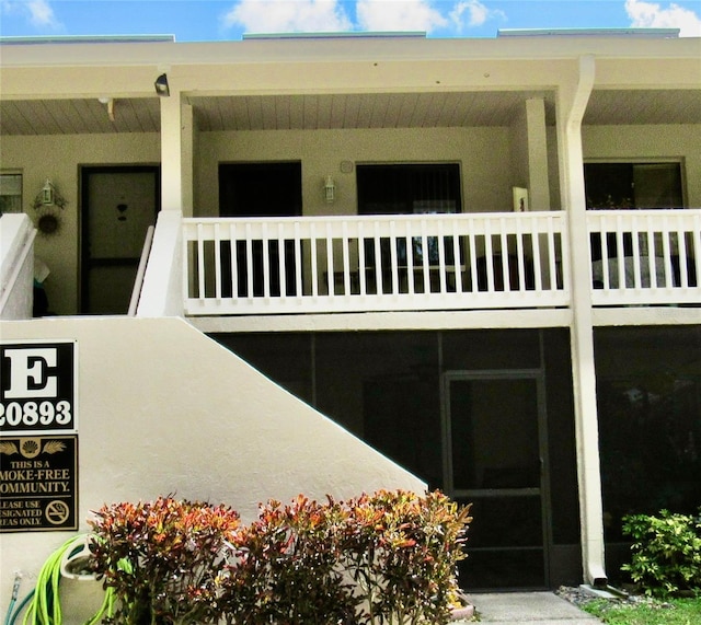 view of exterior entry with a balcony