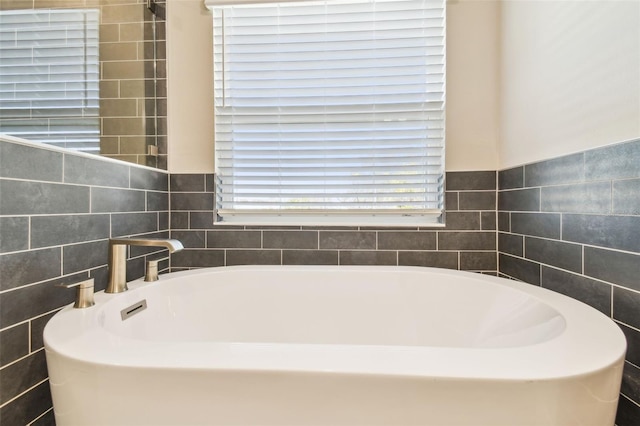 bathroom featuring tile walls and a tub