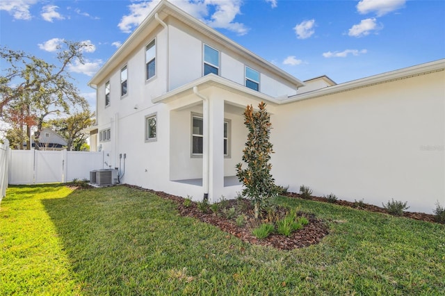 view of side of home featuring central AC unit and a yard