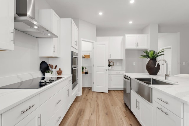 kitchen with white cabinetry, appliances with stainless steel finishes, wall chimney exhaust hood, and sink