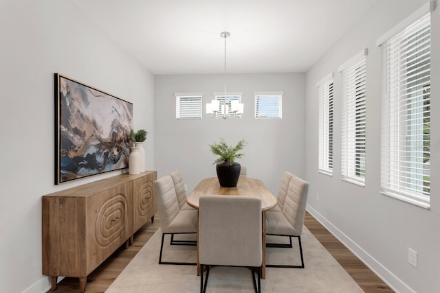 dining room with light hardwood / wood-style floors and a chandelier