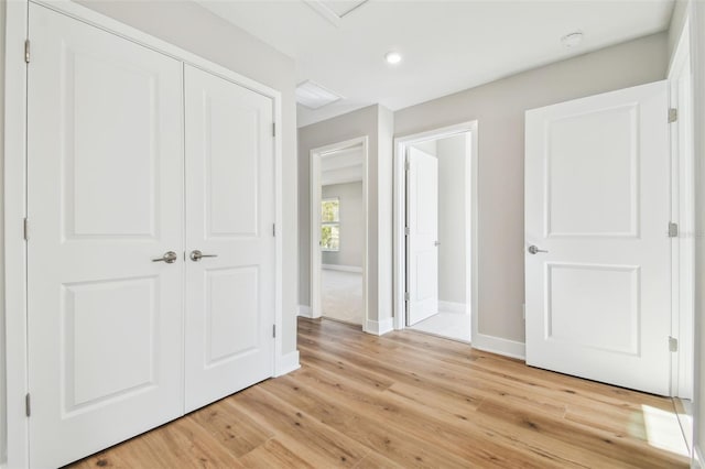 unfurnished bedroom featuring light wood-type flooring and a closet