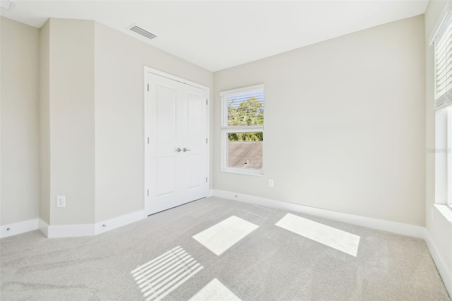 unfurnished bedroom featuring light carpet