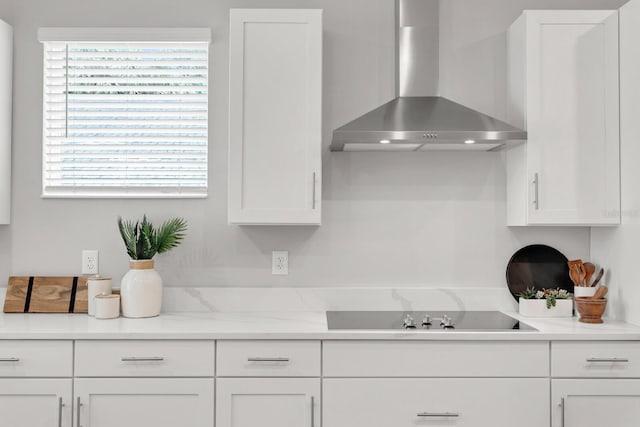 kitchen with white cabinetry, wall chimney range hood, a wealth of natural light, and black electric stovetop