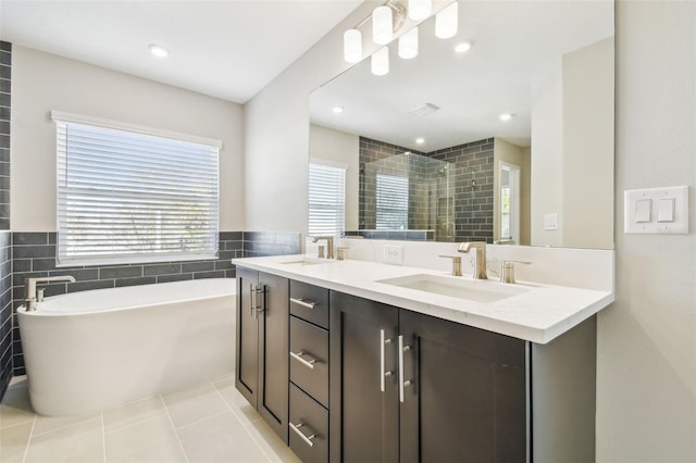 bathroom featuring vanity, independent shower and bath, tile patterned flooring, and tile walls