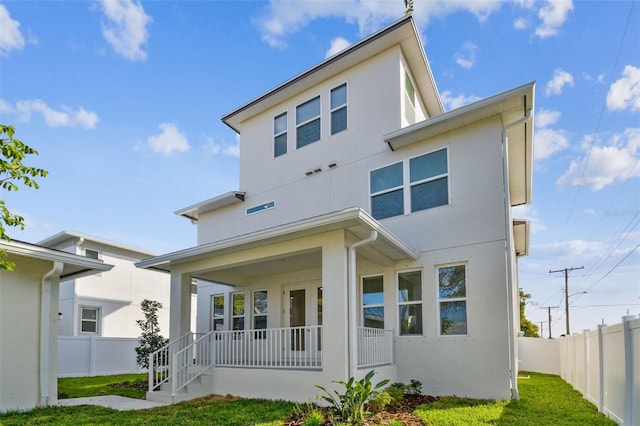 rear view of property with a lawn and a porch