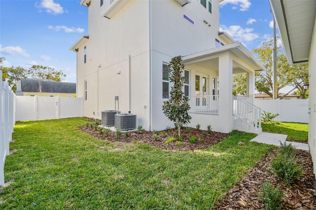 view of home's exterior with a lawn and central AC