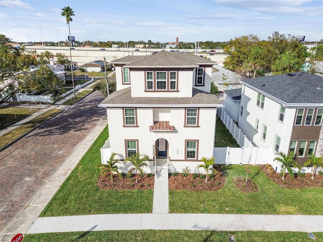 view of front facade with a balcony and a front yard