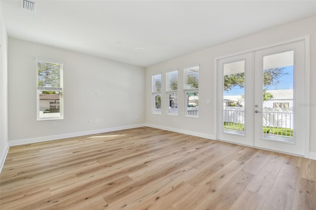 unfurnished room featuring light hardwood / wood-style floors and french doors