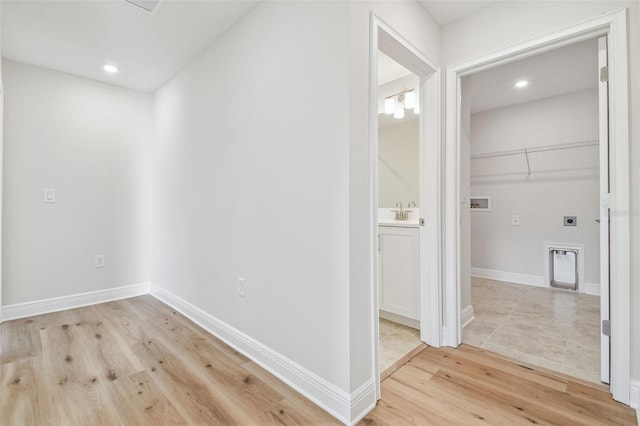 hallway featuring sink and light wood-type flooring