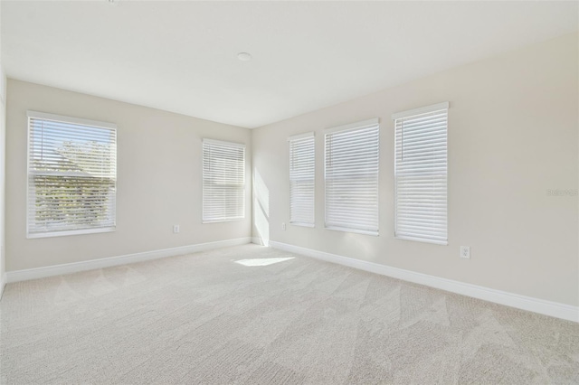 spare room featuring light colored carpet