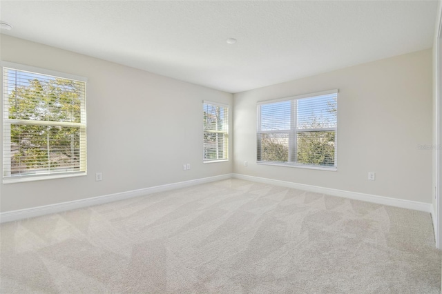 unfurnished room featuring light carpet