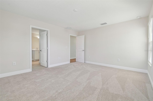 unfurnished bedroom featuring light carpet