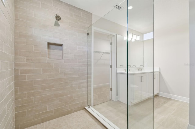 bathroom with vanity and a tile shower