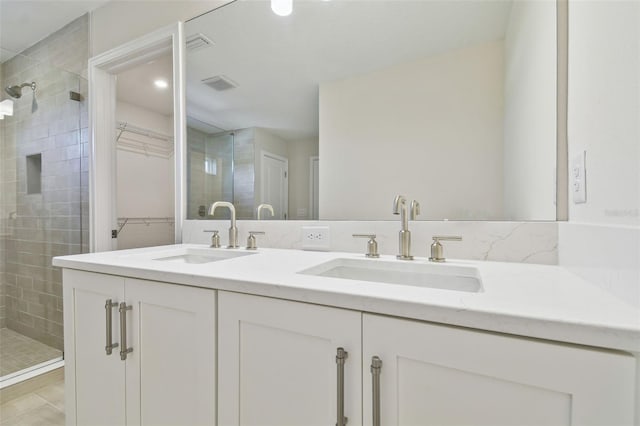 bathroom with a shower with door, tile patterned flooring, and vanity