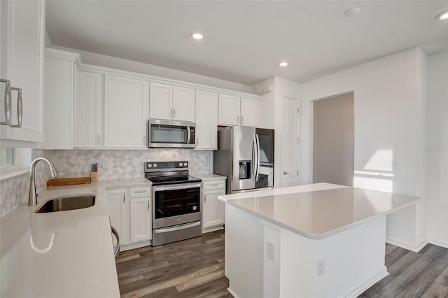 kitchen with a center island, white cabinetry, sink, and stainless steel appliances