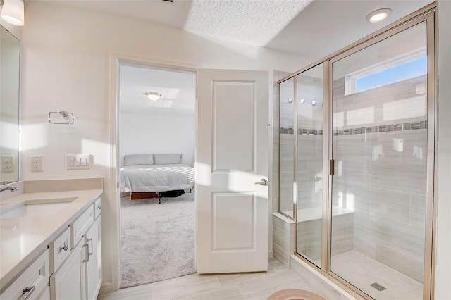 bathroom with oversized vanity, an enclosed shower, a textured ceiling, and tile flooring