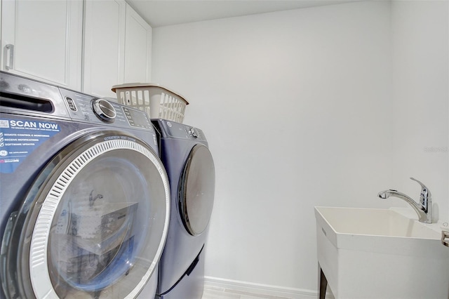 washroom featuring washer and clothes dryer, cabinets, and sink