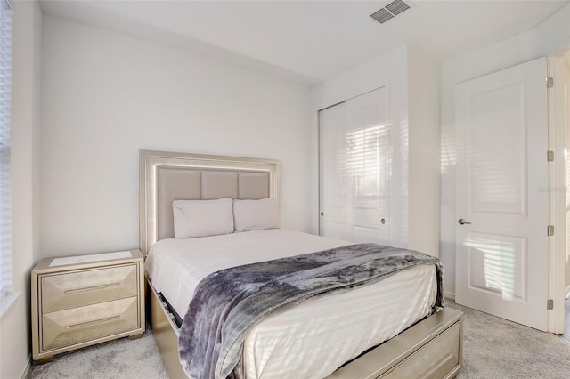 bedroom with light carpet and a closet