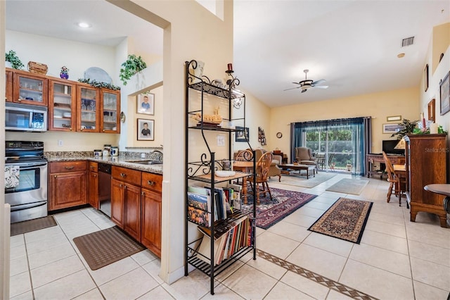 kitchen featuring light tile floors, ceiling fan, and stainless steel appliances