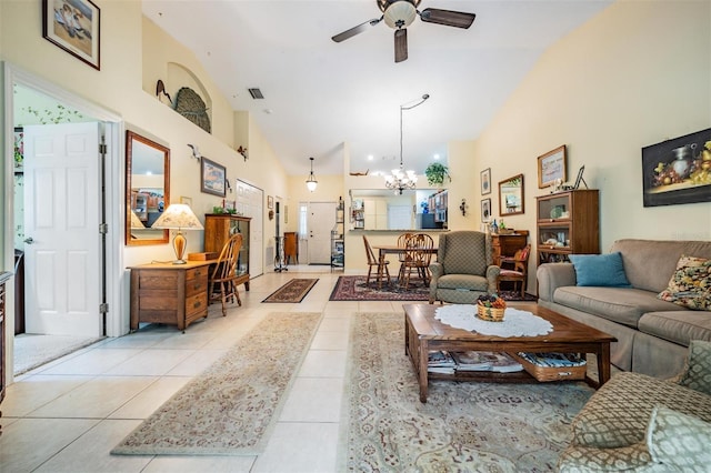 tiled living room featuring high vaulted ceiling and ceiling fan with notable chandelier