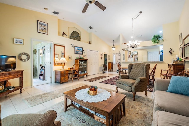 tiled living room featuring high vaulted ceiling and ceiling fan with notable chandelier