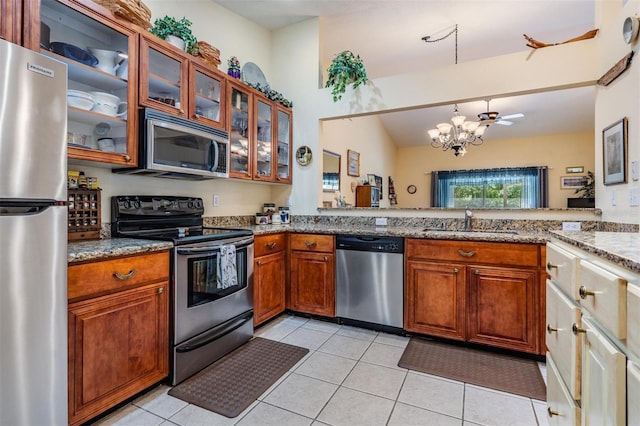 kitchen with stainless steel appliances, light tile floors, and kitchen peninsula