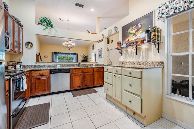 kitchen featuring light tile floors, appliances with stainless steel finishes, a chandelier, and light stone countertops