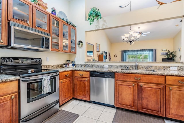 kitchen with sink, light tile floors, stainless steel appliances, light stone countertops, and ceiling fan with notable chandelier