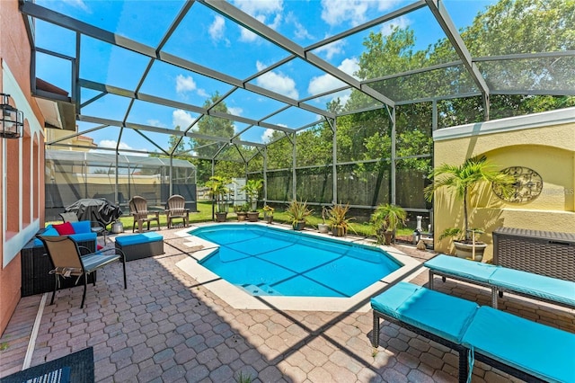 view of pool with outdoor lounge area, a lanai, and a patio area