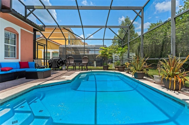 view of swimming pool with a patio area, outdoor lounge area, and glass enclosure