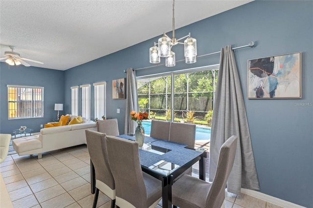 tiled dining room with a textured ceiling, ceiling fan with notable chandelier, and a healthy amount of sunlight