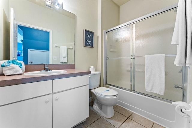 full bathroom with oversized vanity, toilet, enclosed tub / shower combo, and tile flooring