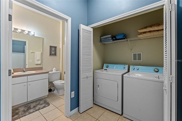 laundry area featuring sink, washing machine and clothes dryer, and light tile flooring