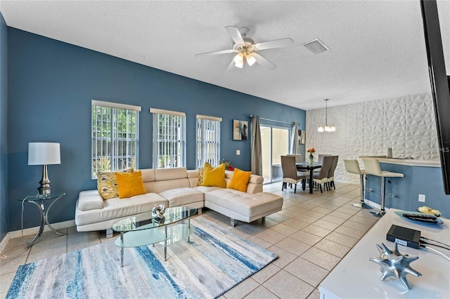 living room with light tile floors, a textured ceiling, and ceiling fan with notable chandelier