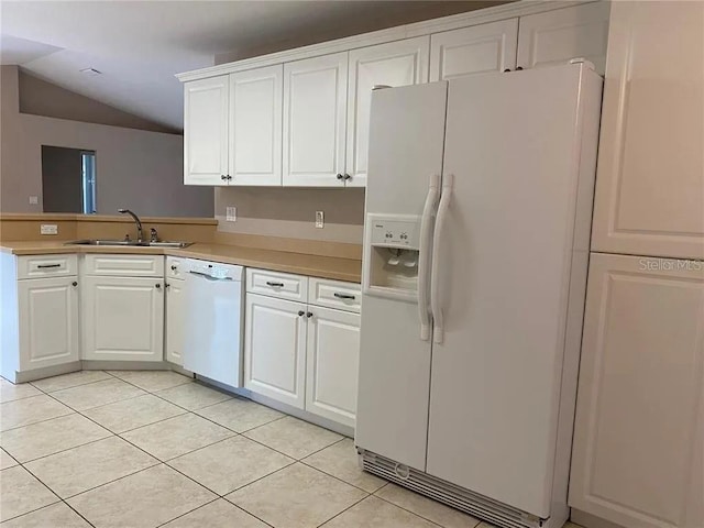 kitchen with light tile flooring, vaulted ceiling, white appliances, white cabinetry, and sink