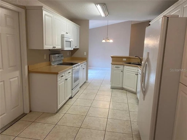 kitchen with white appliances, white cabinetry, and an inviting chandelier