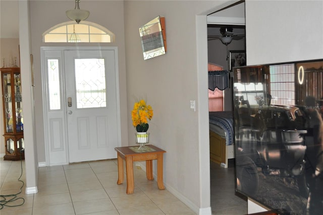 entrance foyer featuring light tile floors, ceiling fan, and a wealth of natural light