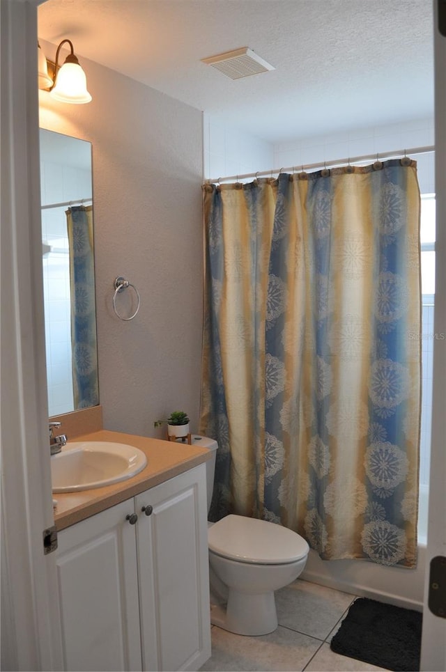 bathroom with tile flooring, vanity with extensive cabinet space, and toilet