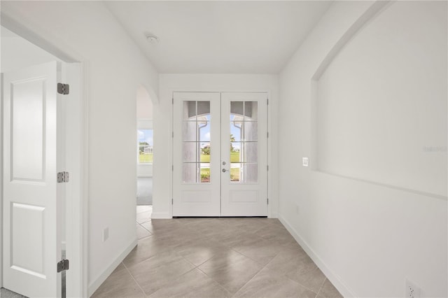 entryway with light tile floors and french doors