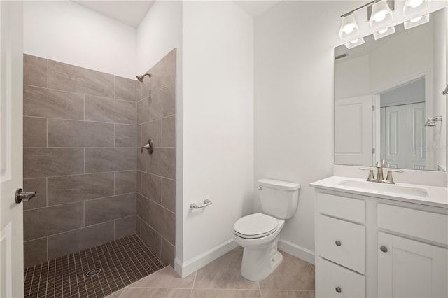 bathroom featuring oversized vanity, toilet, a tile shower, and tile floors